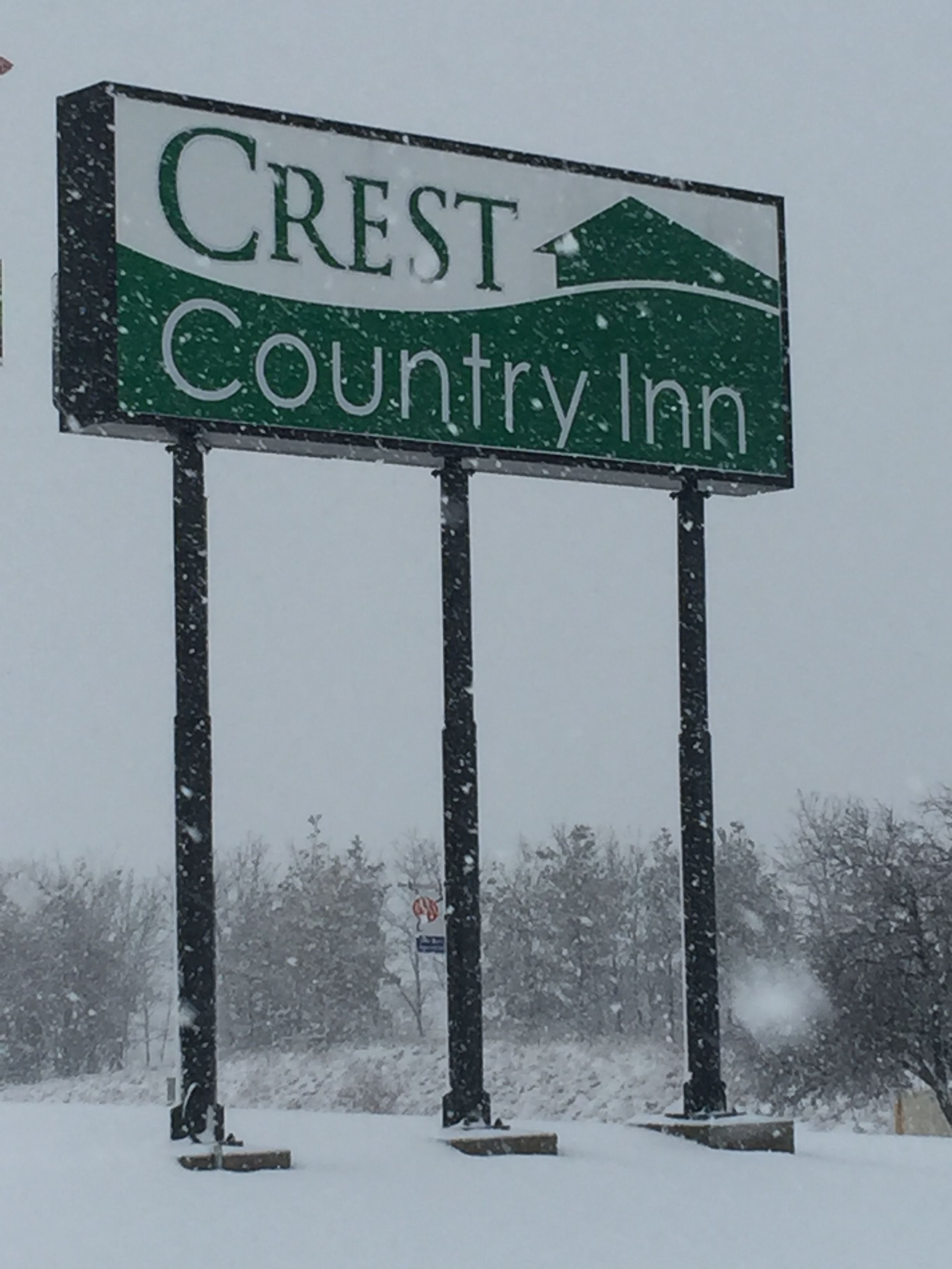 A sign for Crest Country Inn with a mountain graphic.