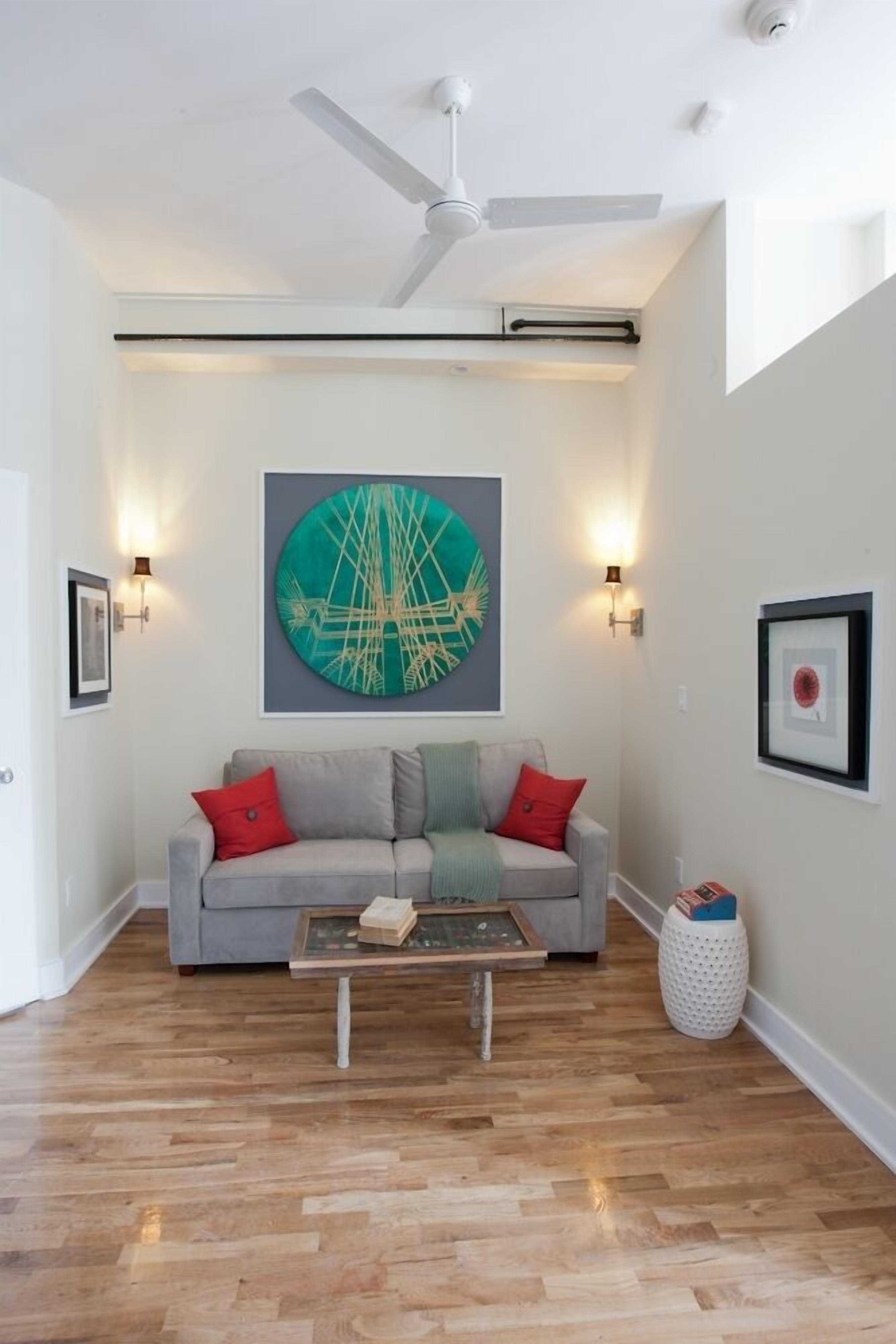 A modern living room with a grey sofa, a coffee table, and a ceiling fan.