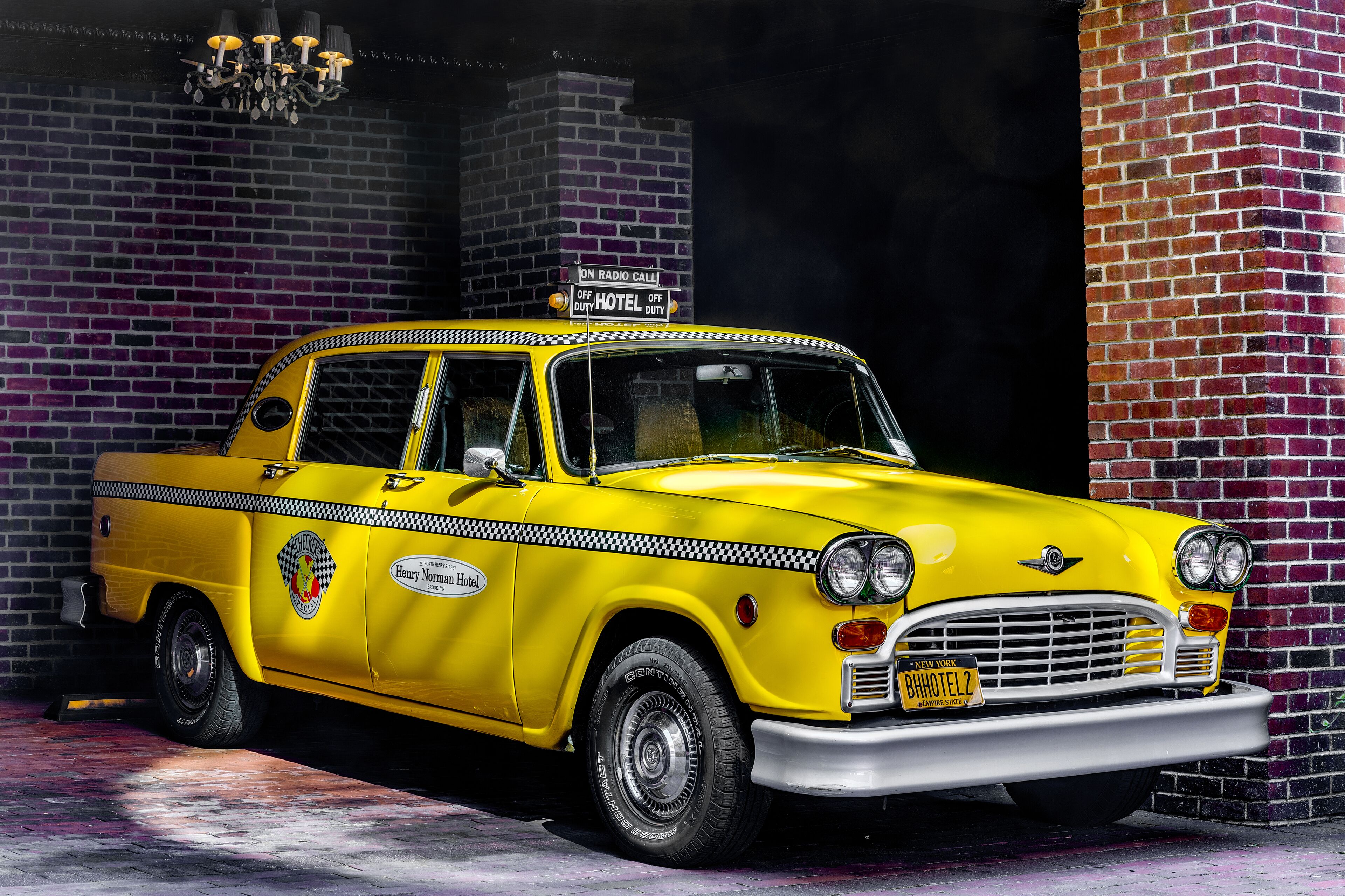 Un taxi jaune d’époque, avec un panneau indiquant qu’il n’est pas en service, est garé devant l’hôtel Henry Norman.