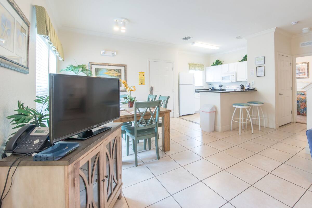 A modern apartment with a living room, dining area, kitchen, and a small balcony.