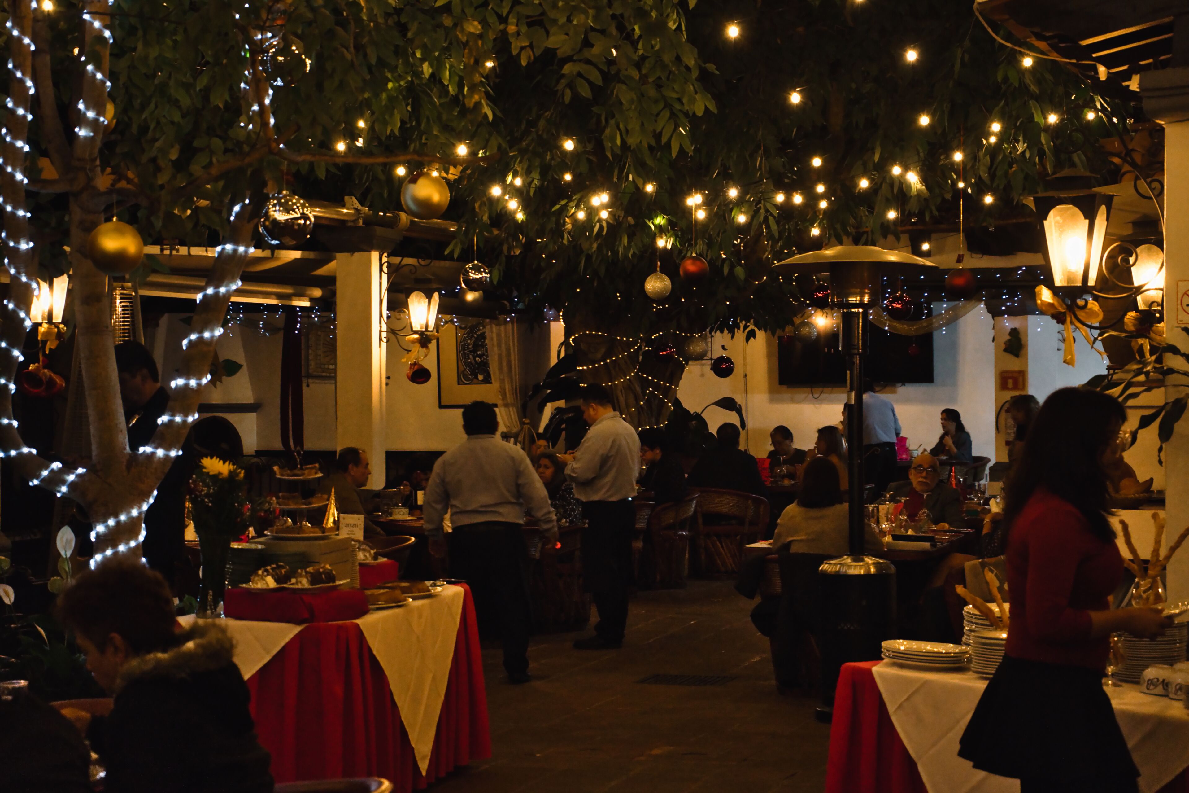 An indoor dining area with tables, chairs, and hanging lights.