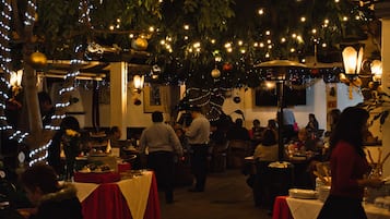 An indoor dining area with tables, chairs, and hanging lights.