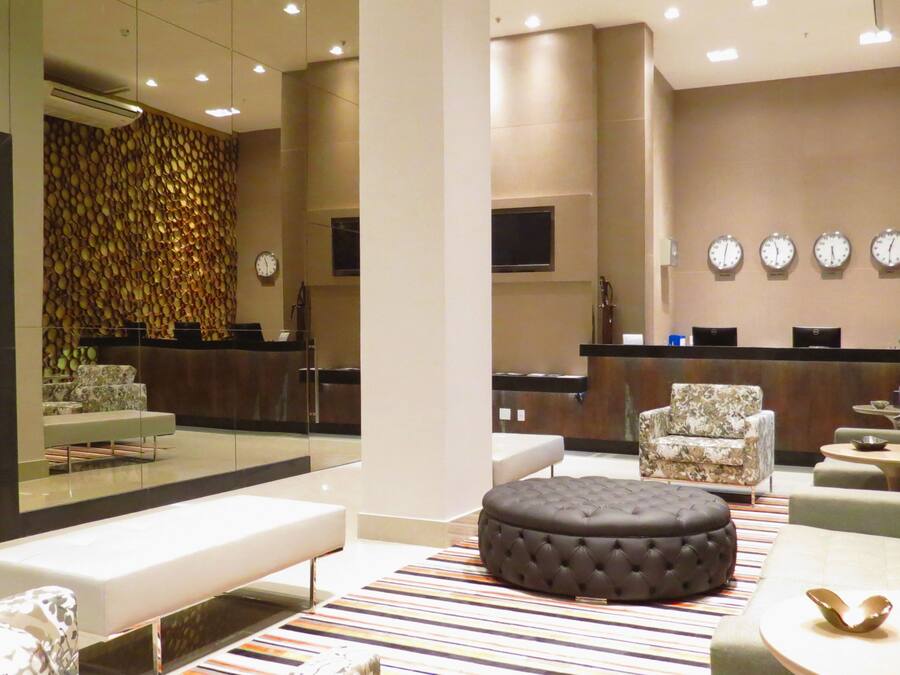 A modern lobby with a reception desk, seating area, and a decorative wall.