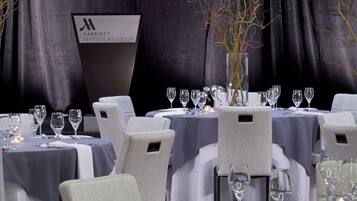 A restaurant setting with tables set for dining, featuring a sign for Marriott Seattle Bellevue.
