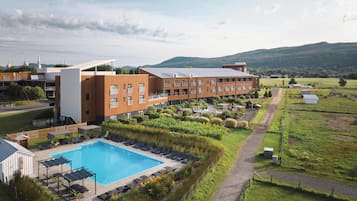 Relax by the large pool surrounded by sun loungers and lush greenery.