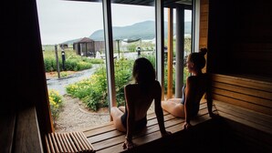 Una sauna con vistas a un jardín y montañas.