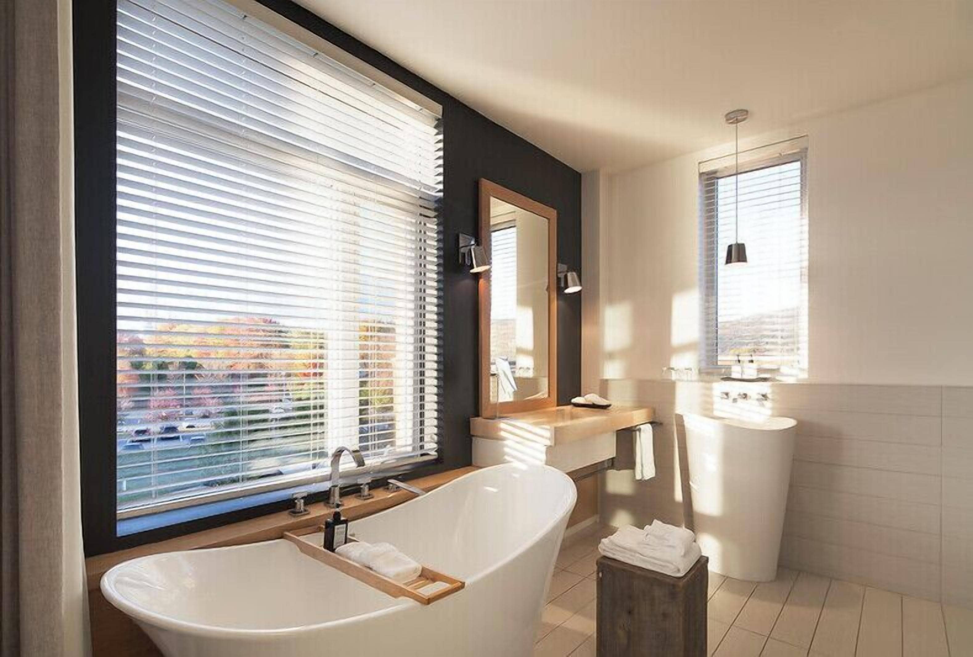 A modern bathroom with a freestanding bathtub, a vanity with a mirror, and a toilet.