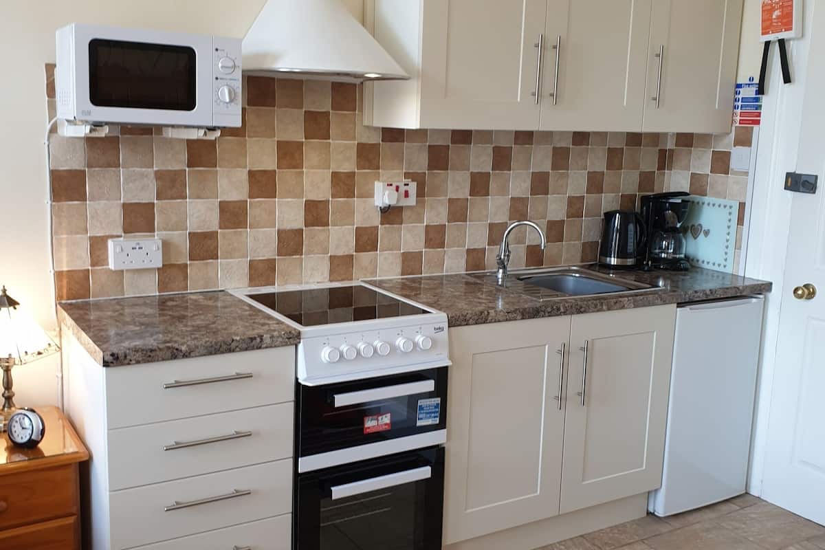 A kitchen with white cabinets, a microwave, a stove, and a dishwasher.