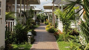 A pathway lined with lush greenery and a covered walkway connecting buildings.