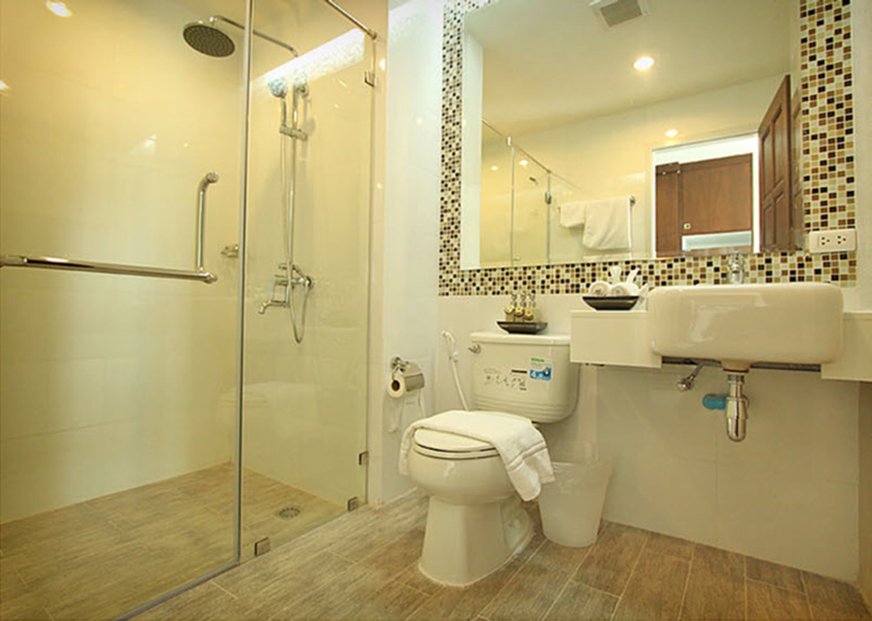 A modern bathroom with a glass-enclosed shower, a toilet, and a sink.