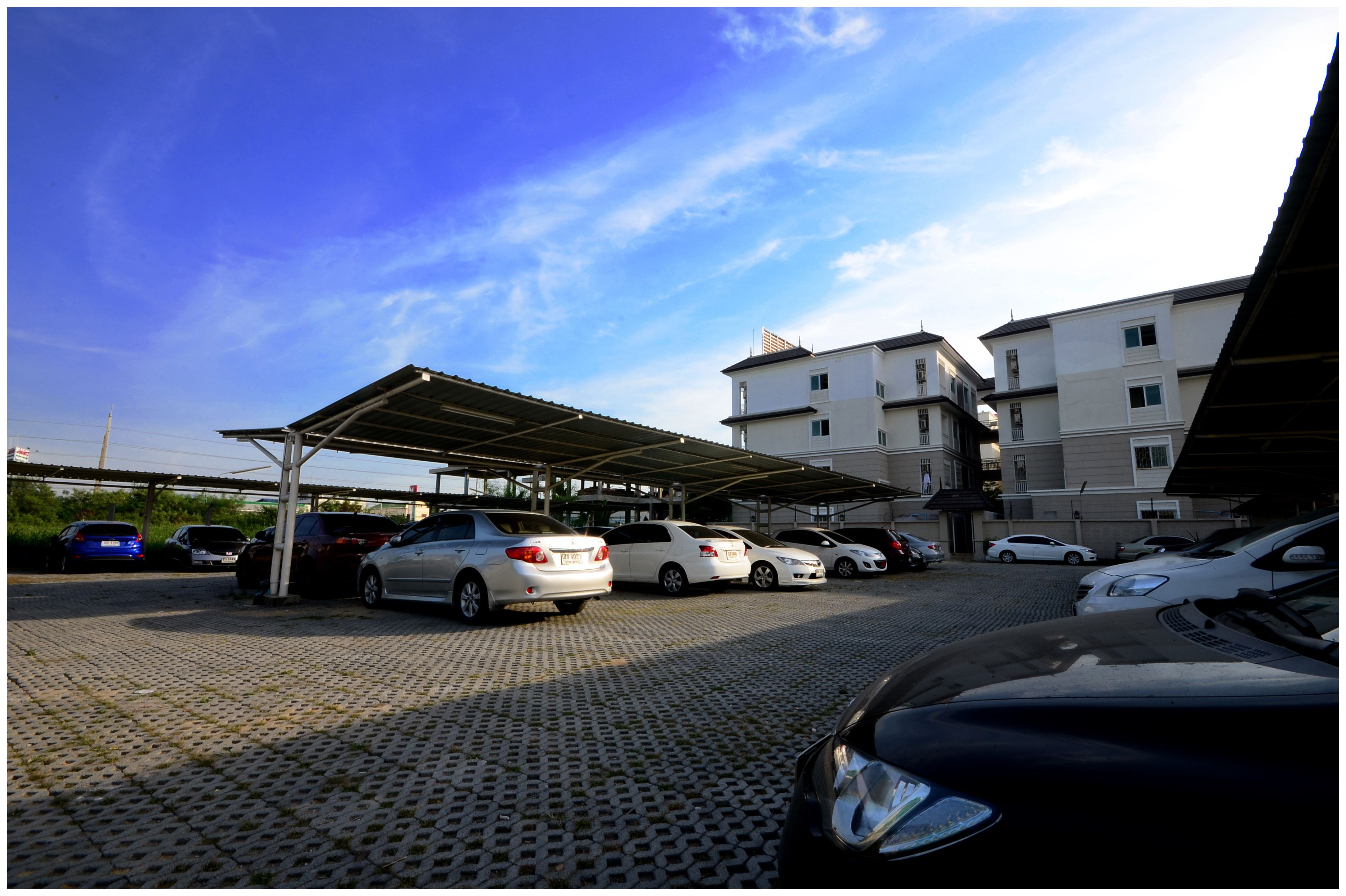 Ein Parkplatz mit mehreren Autos und einer Überdachung.