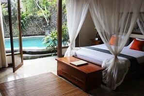 A bedroom with a bed, bedside table, and a view of a swimming pool. - Nefatari Exclusive Villas (Ubud)