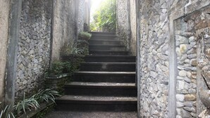 A narrow stone staircase leading up to a higher level, surrounded by stone walls and greenery. - Nefatari Exclusive Villas (Ubud)