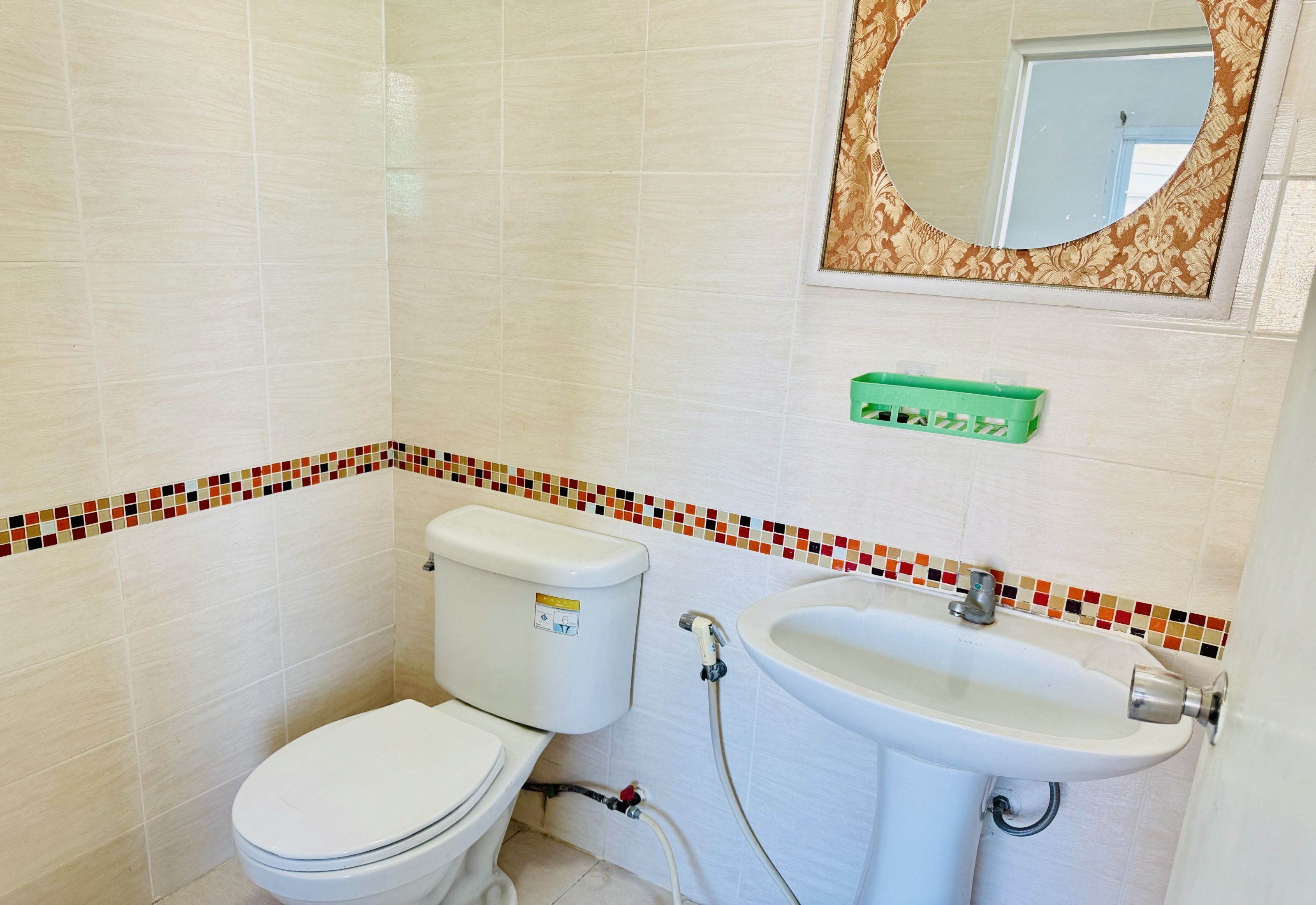 A bathroom with a toilet, sink, and mirror.
