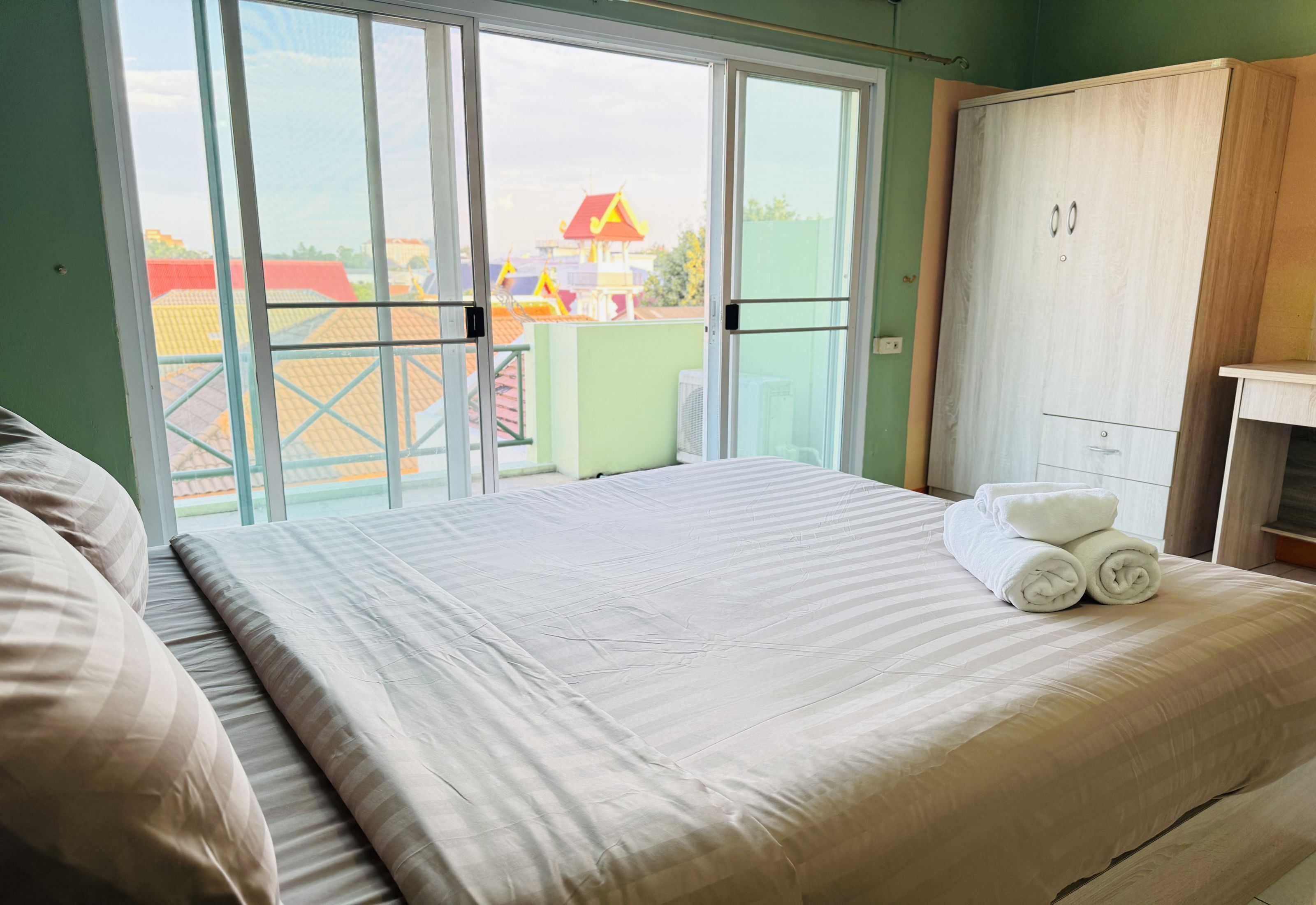 Un dormitorio con cama, armario y vistas al exterior a través de una puerta corredera.