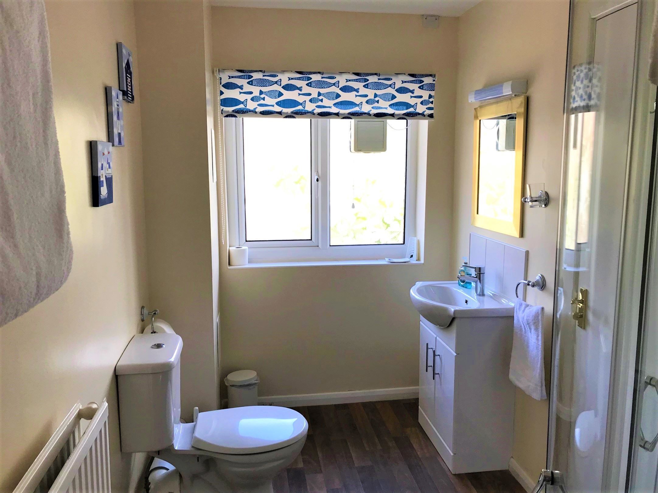 Une petite salle de bain avec des toilettes, un lavabo et une fenêtre.