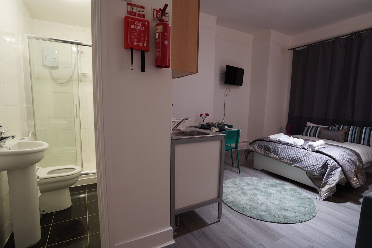 Un dormitorio moderno con cama, mesita de noche y televisor.