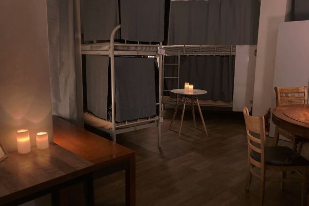 A bunk bed room with a small round table and two candles.