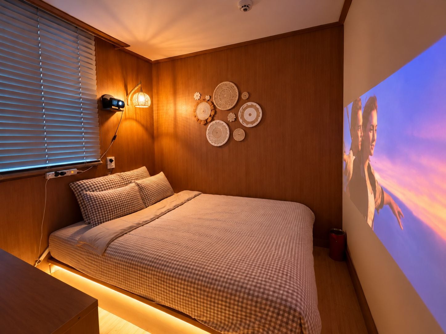 A bedroom with a bed, wall-mounted lamps, and a wall with decorative plates.