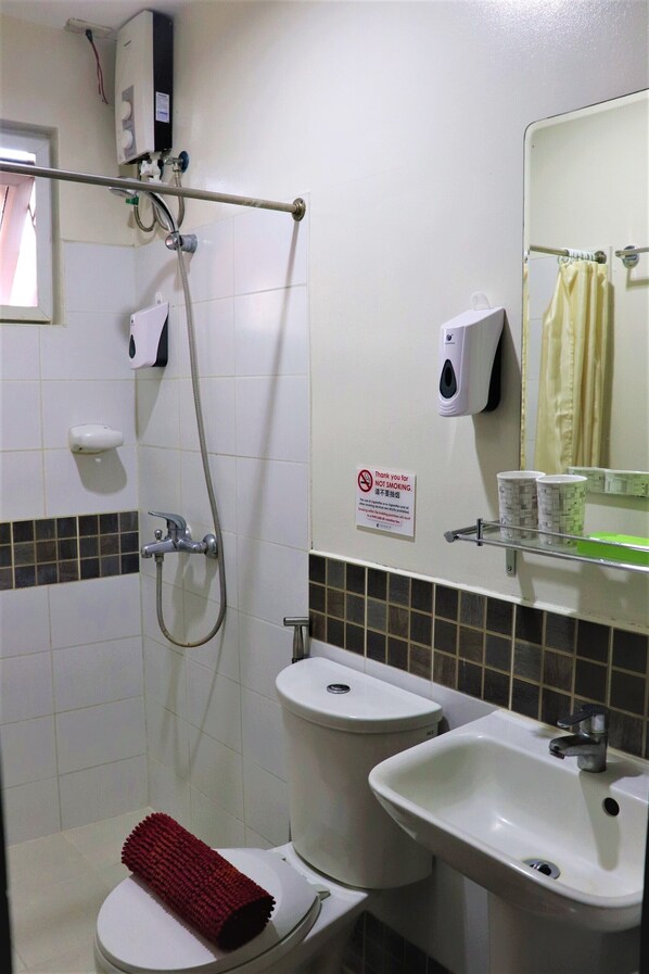 A bathroom with a shower, toilet, and sink.