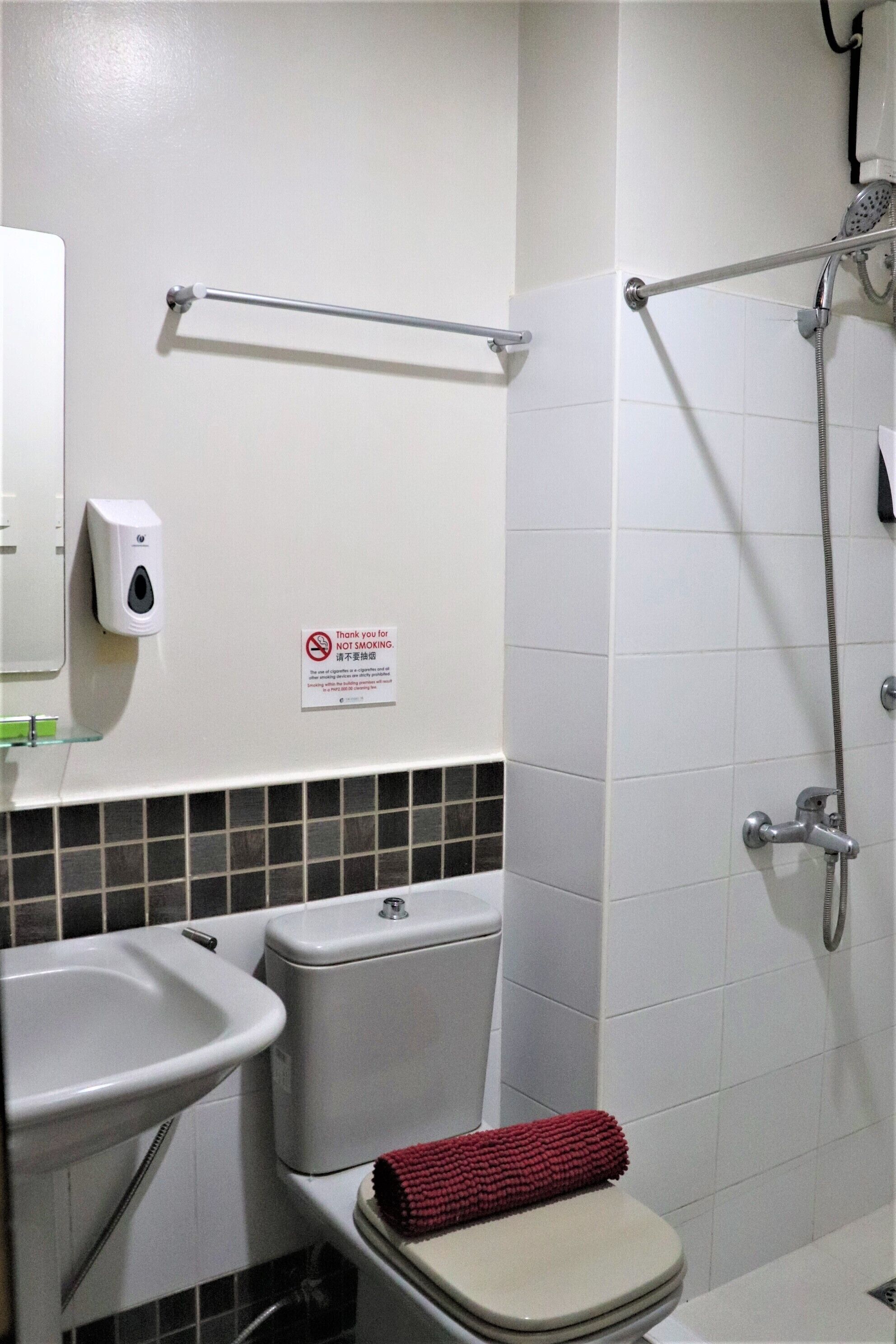 A bathroom with a sink, toilet, and shower.
