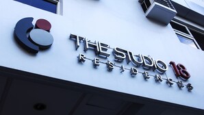 Un edificio con un cartel que dice "The Studio 18 Residences".
