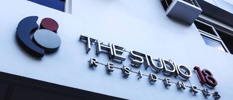 A building with a sign that reads "The Studio 18 Residences".