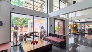 Un hall d’entrée spacieux avec un grand espace salon, une vue sur l’extérieur et un comptoir d’accueil.