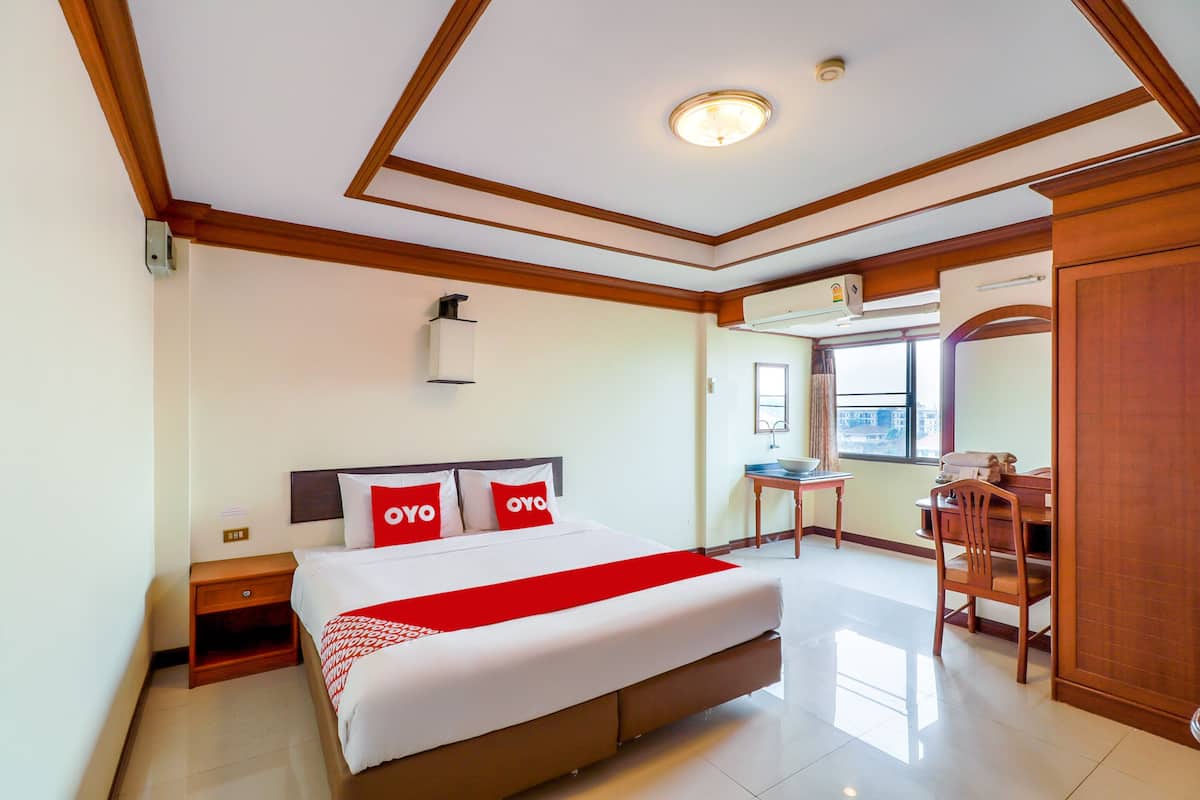 Una habitación de hotel con una cama grande, un escritorio y una silla.
