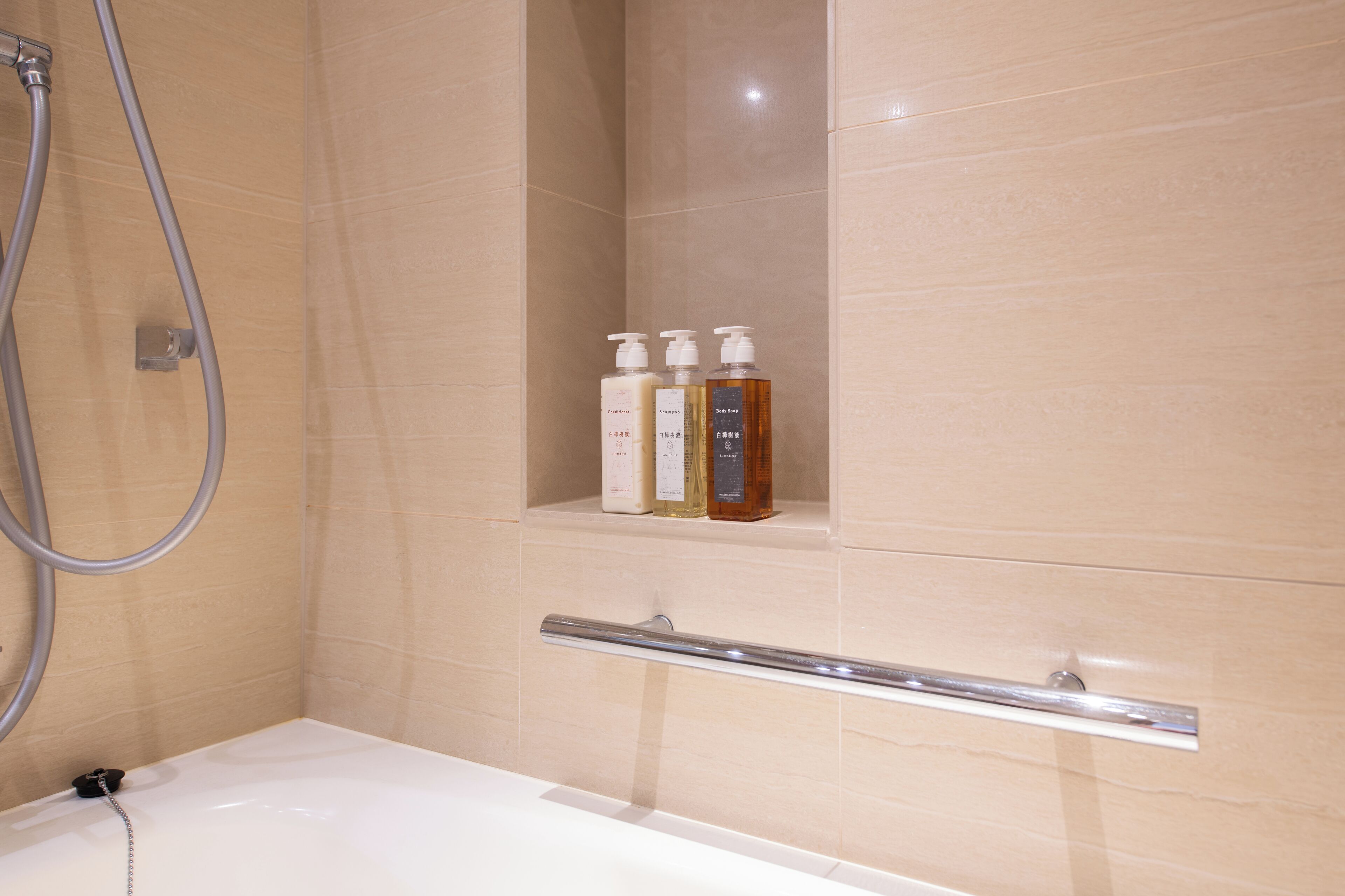 A bathroom with a shower, a bathtub, and a shelf with toiletries.