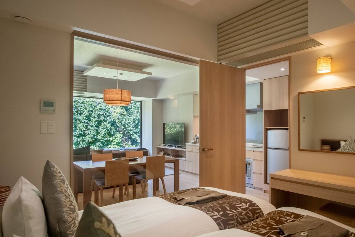 A modern bedroom with a bed, bedside table, and a large mirror.