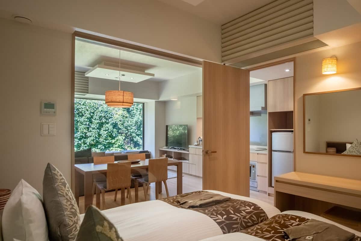 Un dormitorio moderno con cama, mesita de noche y un espejo grande.