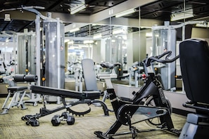 A gym with various exercise equipment, including a stationary bike and weight machines.