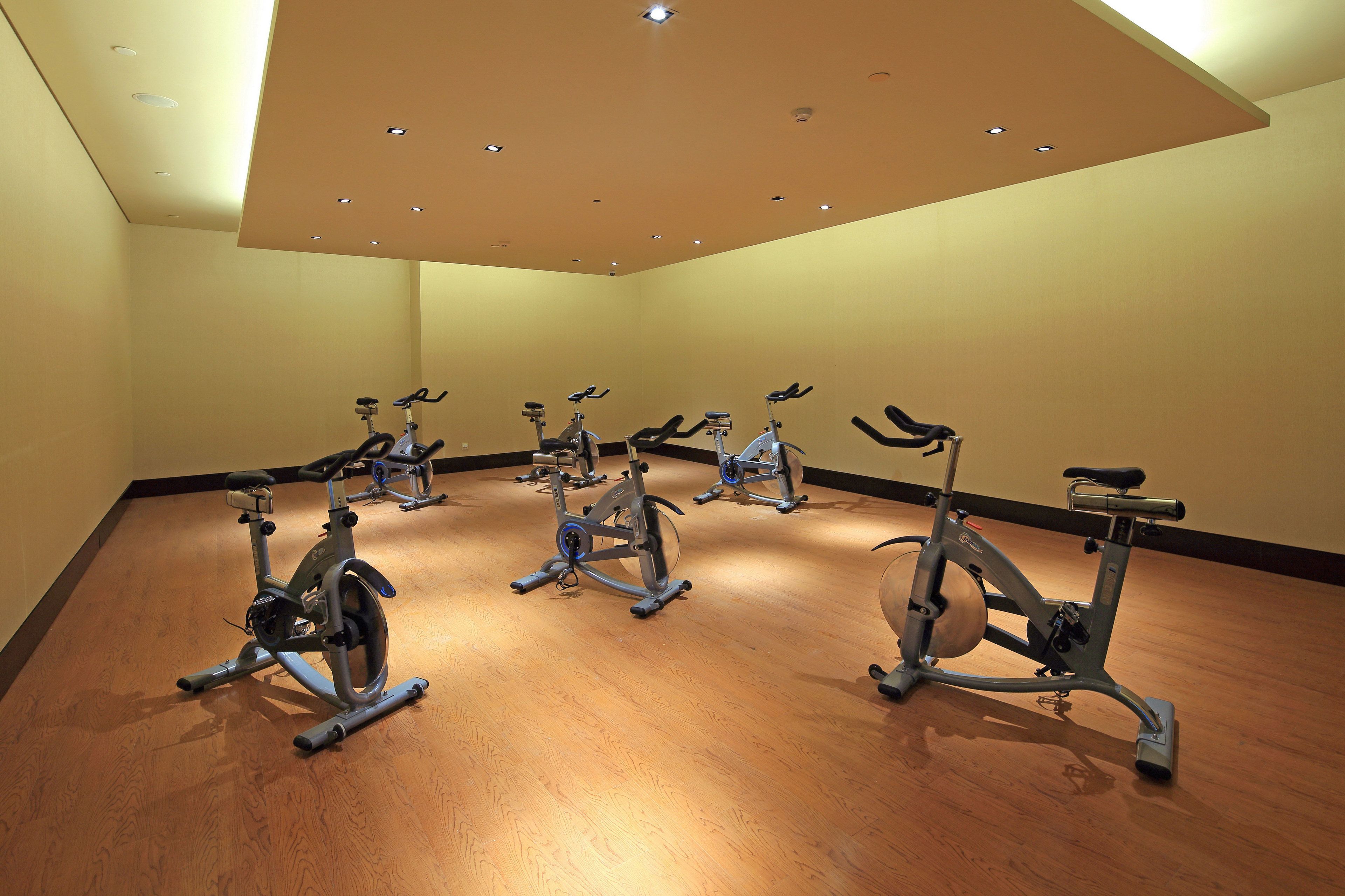 Une salle où plusieurs vélos d’appartement sont disposés en rangée.
