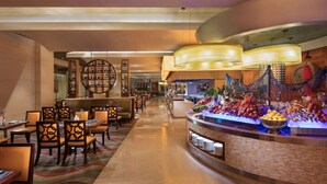 A hotel lobby with a seafood display, seating area, and a bar. - Hilton Qingdao Golden Beach (Qingdao)