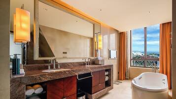 A modern bathroom with a large mirror, dual sinks, a bathtub, and a view of a landmark building.