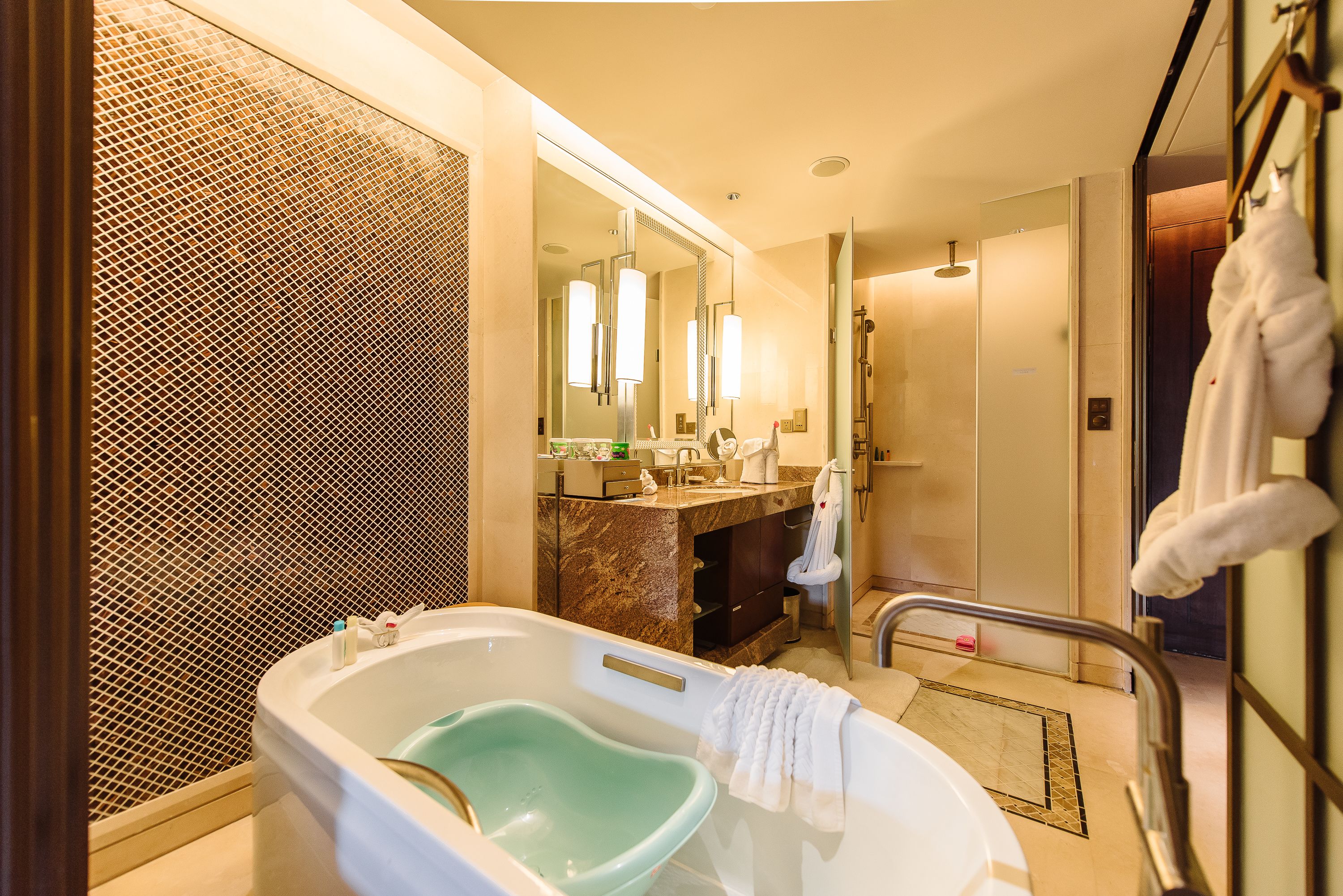 A modern bathroom with a freestanding bathtub, a large mirror, and a walk-in shower.