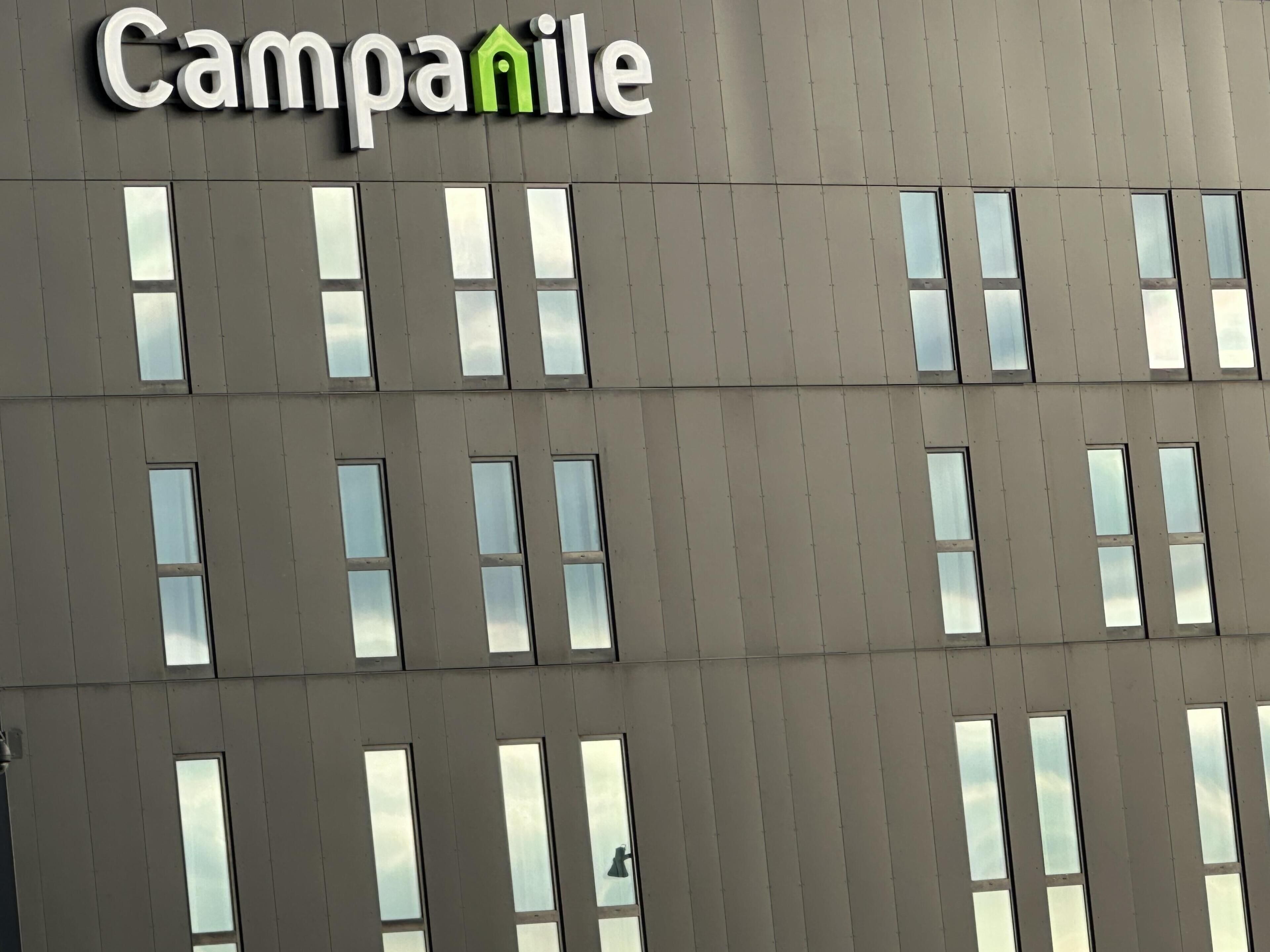 A building facade with a sign reading 'Campanile' and multiple windows.