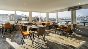 A spacious dining area with large windows, wooden flooring, and modern furniture. - Sayeban Gold Hotel (Istanbul)