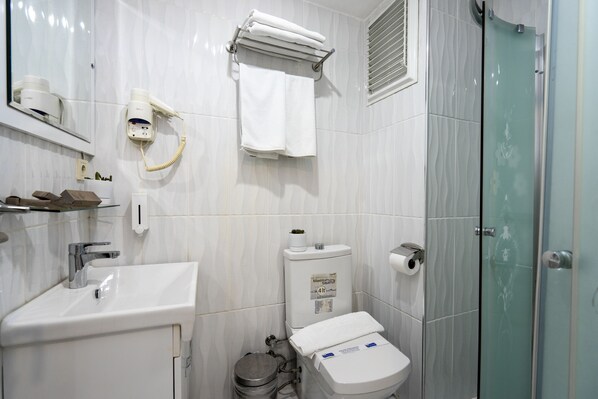 A bathroom with a sink, toilet, and shower.
