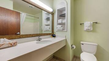 A bathroom with a white sink, a mirror, a toilet, and a towel rack.