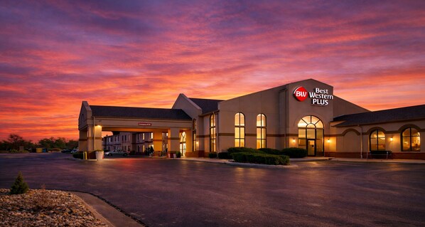 A Best Western PLUS hotel with a gas station, large windows, and a parking lot.