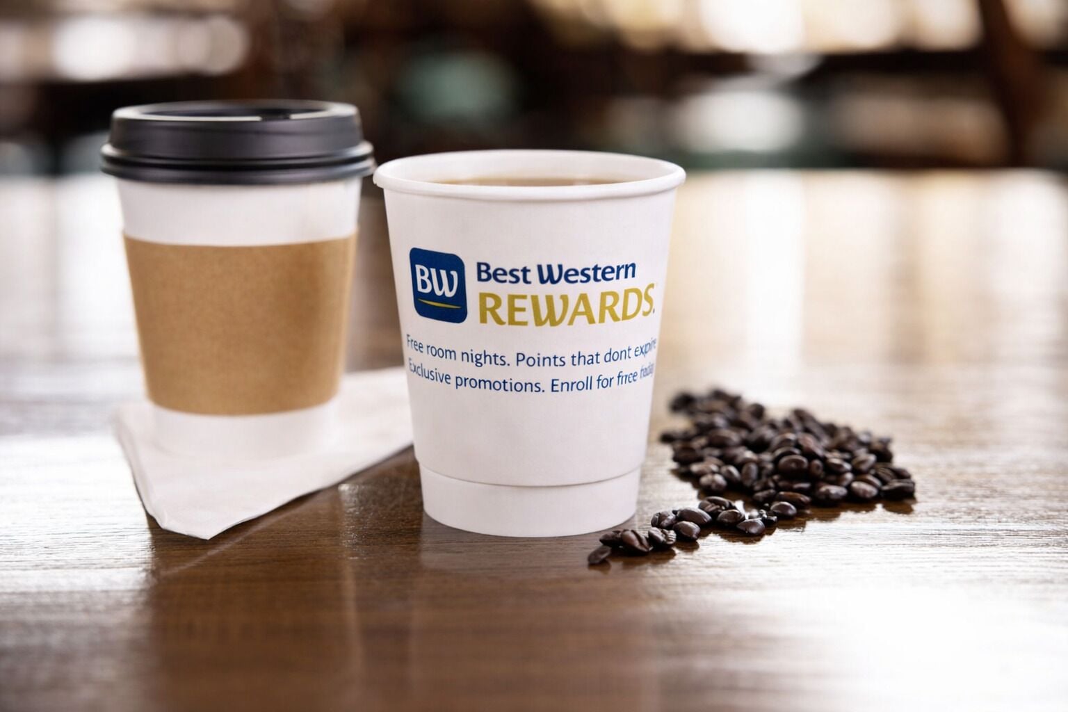 Dues tasses de cafè amb un vessament de gra de cafè sobre una superfície de fusta.
