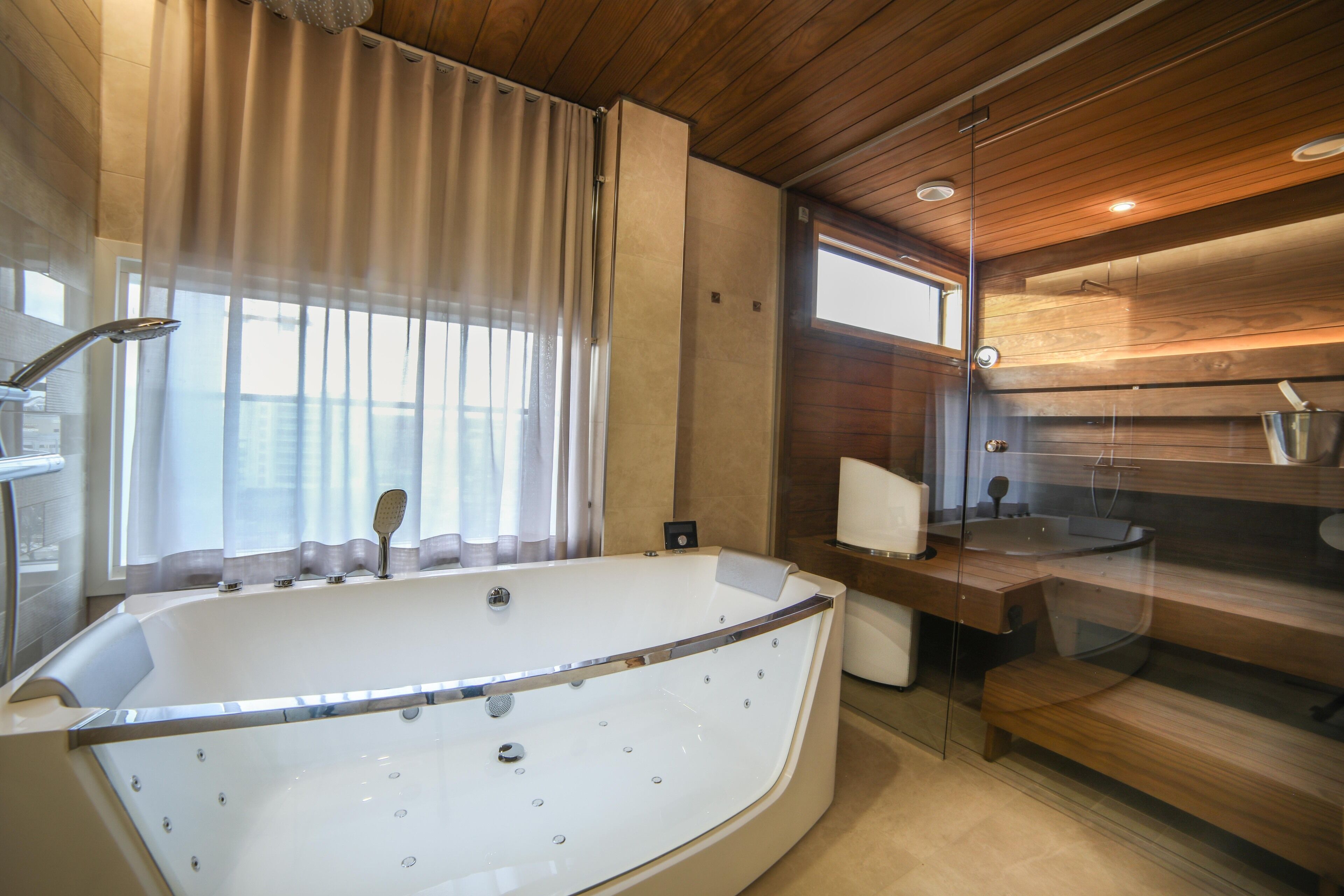 Une salle de bain moderne avec une baignoire sur pieds, une douche en verre et un lambris en bois sur les murs.