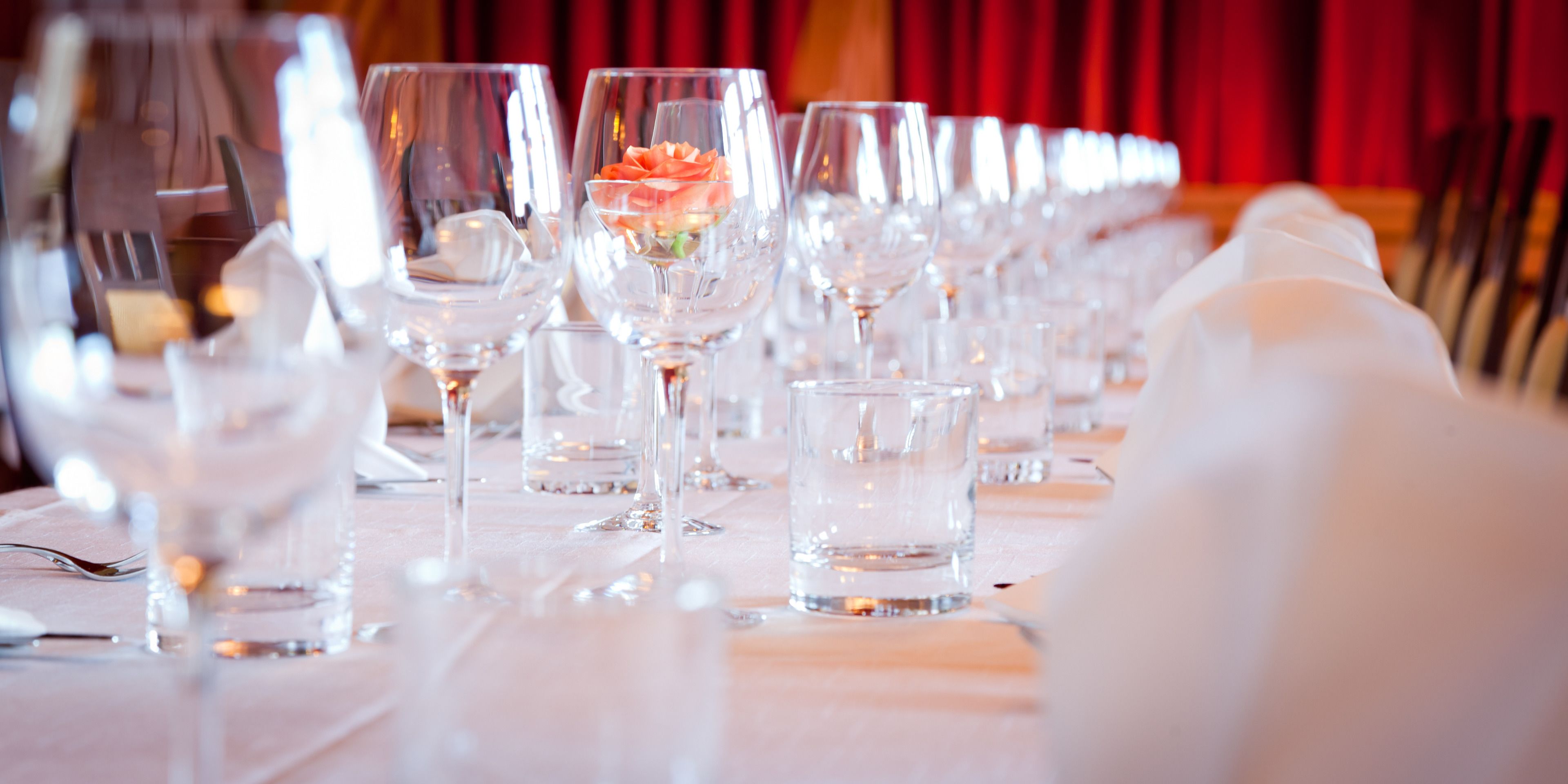 A table set for a formal event with multiple wine glasses and forks.