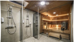 Un baño moderno con ducha de vidrio, armarios de madera y un banco.