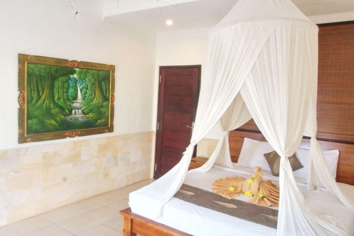 Un dormitorio con cama con dosel, un cuadro en la pared y una puerta de madera.