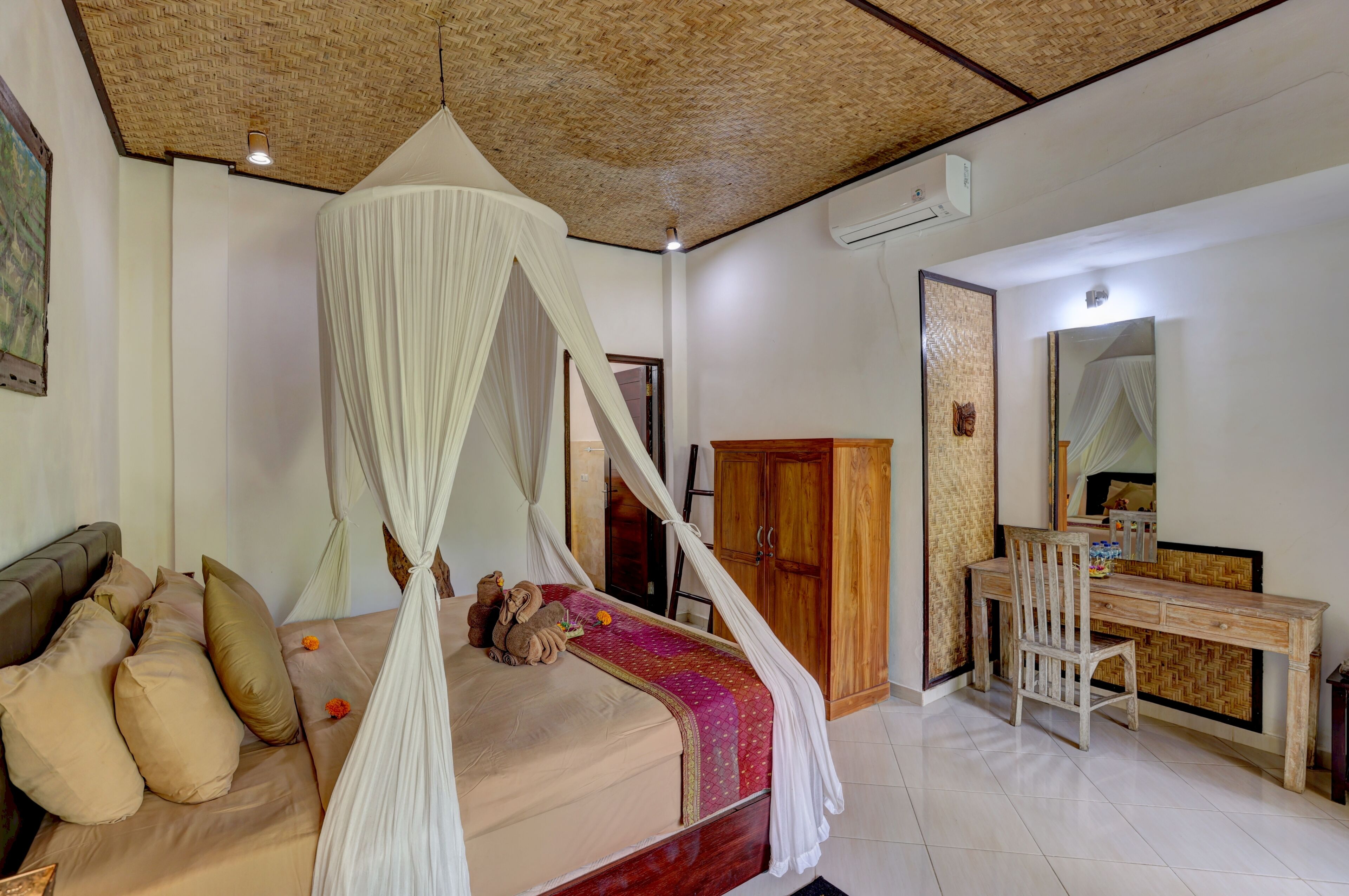 A bedroom with a bed, a desk, and a wardrobe.