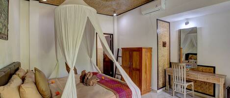 A bedroom with a bed, a desk, and a wardrobe.