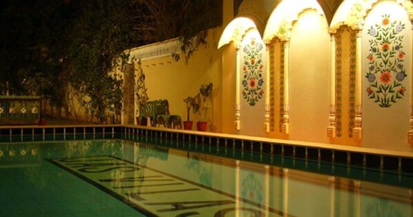 Una piscina con superficie de agua cristalina y un cartel en el borde.